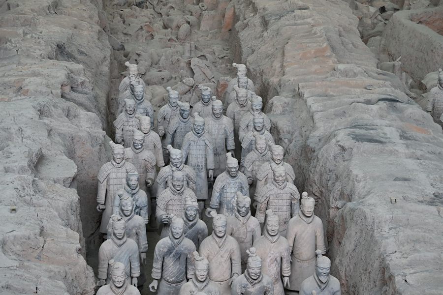 Rows of terracotta warriors standing in an excavated pit at Xi’an